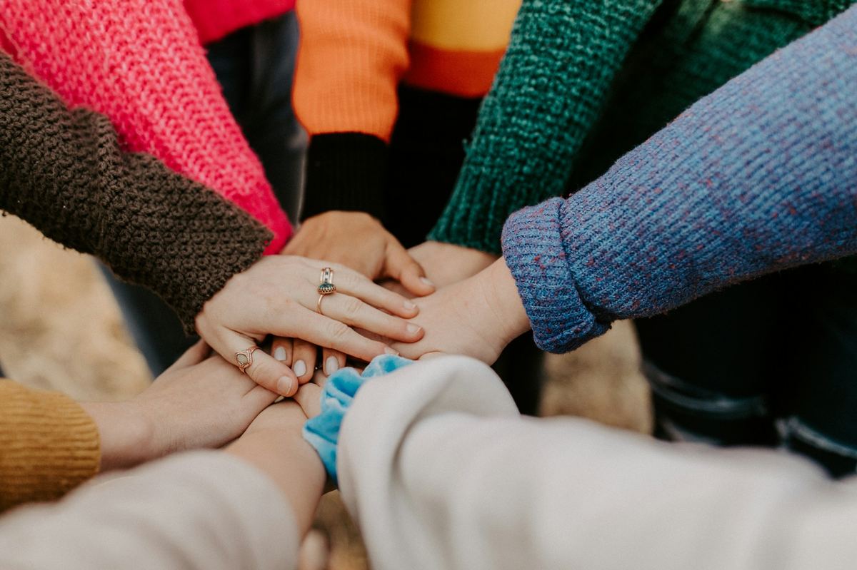 A team's hands stacked together in commitment