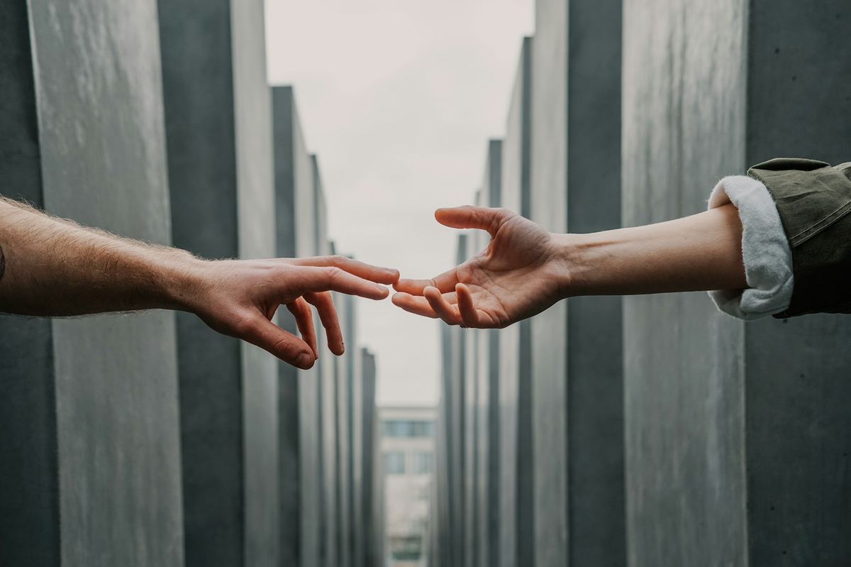 Two hands reaching toward each other in connection